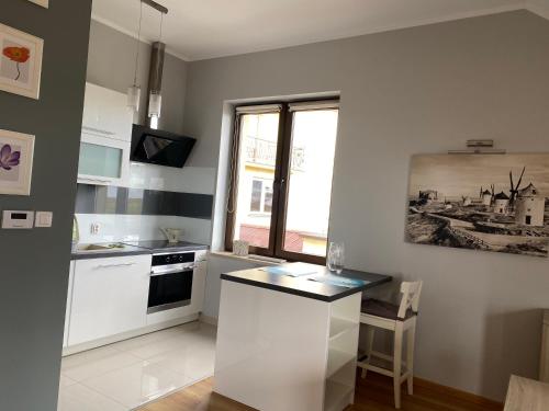 モドルニツァにあるLipowaの白いキャビネット、シンク、窓付きのキッチン