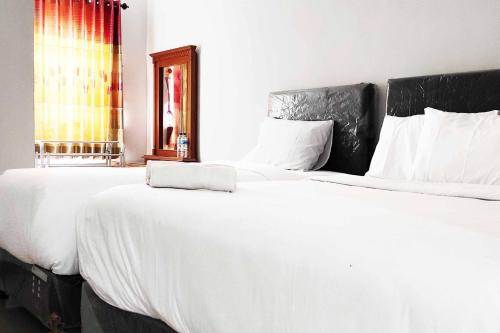 Postel nebo postele na pokoji v ubytování Pertiwi Homestay Near Museum Angkut Batu Mitra RedDoorz