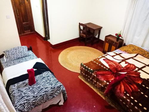 a room with two beds in a room with arero at Shimbwe Meadows Home in Moshi