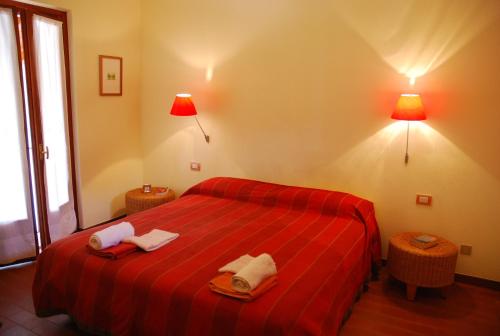 a bedroom with a red bed with two towels on it at B&B Selve di Rogaro in Tremezzo