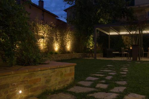 a garden at night with lights on the side of a building at Antico Sipario Boutique Hotel, BW Signature Collection in Paciano