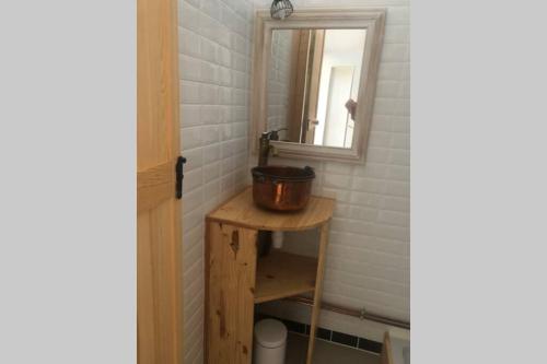 une salle de bain avec un lavabo et un miroir dans l'établissement Grands Buffets hébergement Appartement Narbonne, à Narbonne