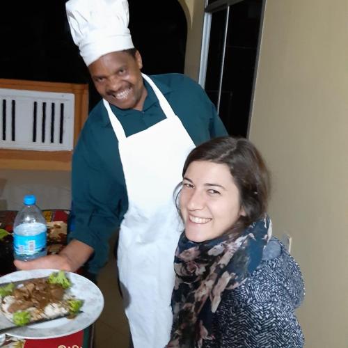 a man and a woman in a kitchen with a plate of food at Shimbwe Meadows Home in Moshi