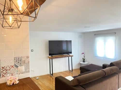 a living room with a couch and a flat screen tv at Bertoko Urdaibai II in Bermeo
