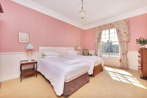 a bedroom with two beds and a window at No1 The Mansions By Mansley in London