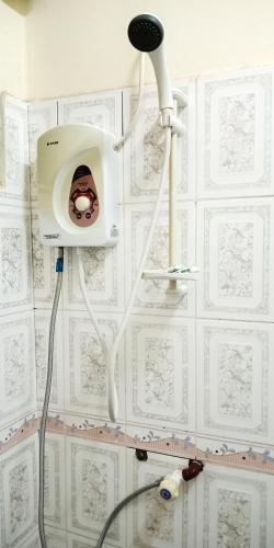 a shower in a bathroom with a white tiled wall at Shimbwe Meadows Home in Moshi