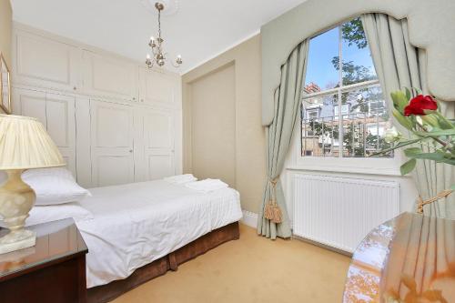 a white bedroom with a bed and a window at No1 The Mansions By Mansley in London