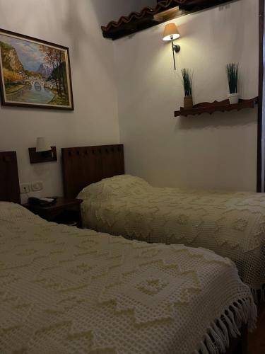 a bedroom with two beds and a picture on the wall at Hotel Mangalemi in Berat