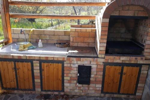 una cocina al aire libre con horno en un patio en Casa cu fantana, en Borleşti