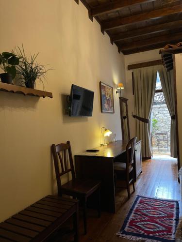 un soggiorno con scrivania, sedie e TV di Hotel Mangalemi a Berat