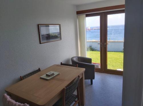 a dining room with a table and a view of the ocean at Four waves in Thurso