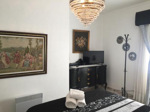 a bedroom with a bed and a painting and a chandelier at Casa Vintage Guest House in Peniche