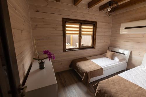 a bedroom with two beds in a wooden cabin at Family Wood in Svityazʼ