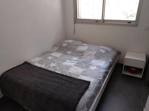 Habitación pequeña con cama con edredón en Le Club, en Cassis