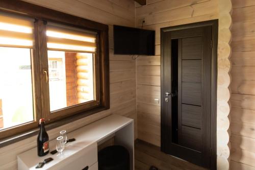 a bathroom with a sink and a window and a television at Family Wood in Svityazʼ