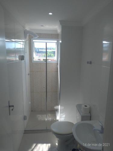 a white bathroom with a shower and a toilet at AP 2 dormitórios NOVO em Montenegro edif Malta 302 in Montenegro