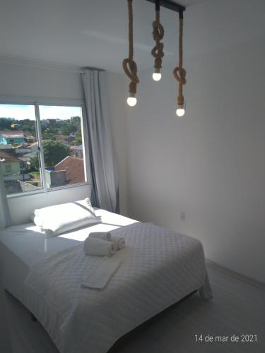 1 dormitorio con 1 cama con 2 toallas en AP 2 dormitórios NOVO em Montenegro edif Malta 302, en Montenegro