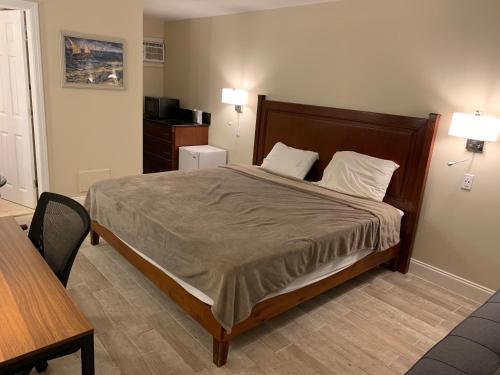 a bedroom with a bed and a table and two lamps at Dunes by the Ocean in Point Pleasant Beach
