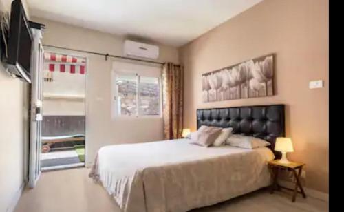 1 dormitorio con 1 cama grande y TV en Estrella del Mar, en Los Abrigos