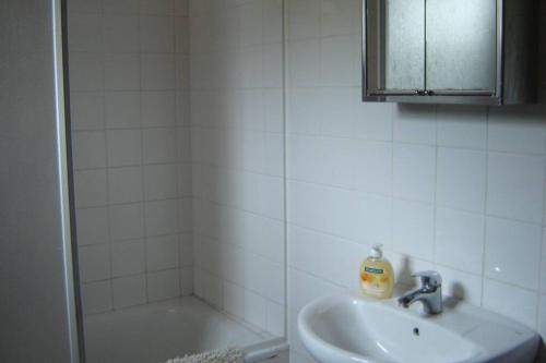 a white bathroom with a sink and a shower at Silveira's Home in Lajes do Pico