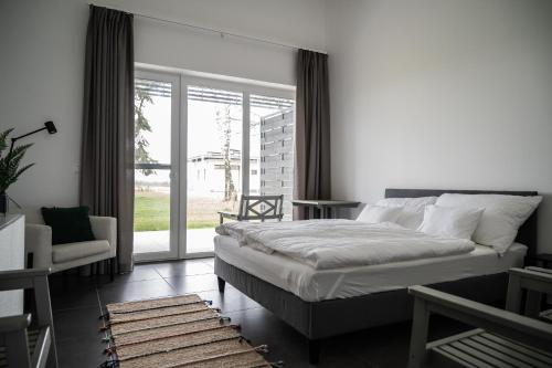 a bedroom with a bed and a large window at Sun City Vízisport Paradicsom in Hódmezővásárhely