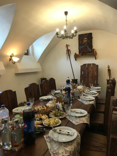 a dining room with a long table with plates of food at Готельний комплекс Трапезна in Subbotov