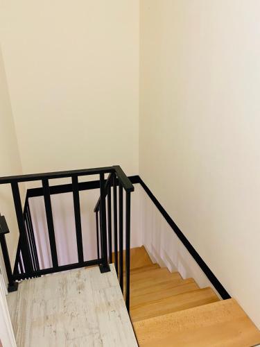 a staircase with a black railing and wooden floor at Chalet Kvariati in Kvariat'i