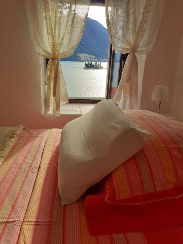 a bedroom with a bed and a window with a view at BellaVistaZmukic Guesthouse in Perast