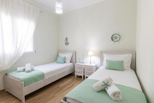 two beds in a room with white and green at Hestia Harmony Living in Limenaria