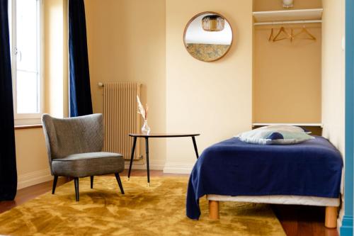 1 dormitorio con 1 cama, 1 silla y 1 mesa en Le Moulin Du Port, en Saint-Georges-sur-Cher