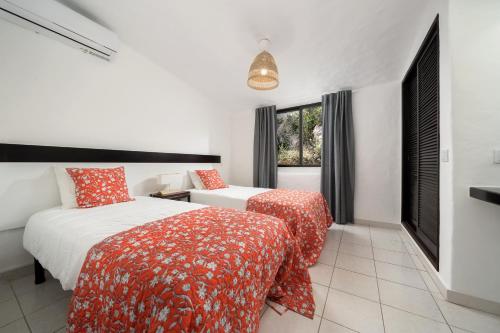 sypialnia z 2 łóżkami i oknem w obiekcie Casa Goa-Quinta do Paraíso, Carvoeiro Beach w mieście Carvoeiro