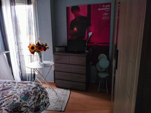 a bedroom with a dresser with a tv on it at Paris 7 minutes chambre hôte parking avec supplément in Le Kremlin-Bicêtre