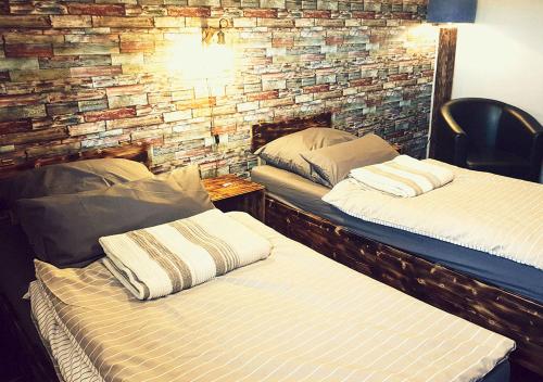 two beds in a room with a brick wall at Hotel Geismarburg in Göttingen