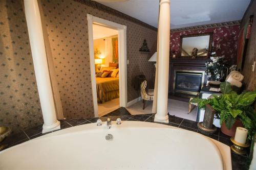 eine Badewanne in einem Zimmer mit einem Schlafzimmer in der Unterkunft Woodstock Inn Bed & Breakfast in Independence