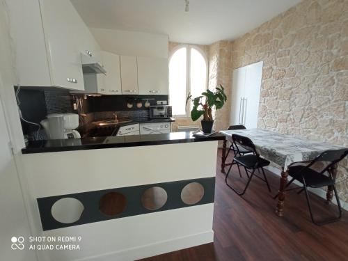 cocina con mesa y sillas en una habitación en LE P'tit logement de lor'Phée, en Chantepie