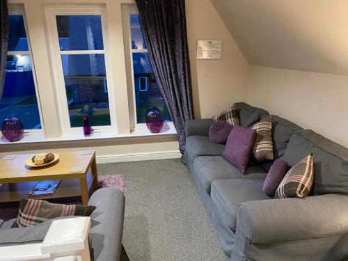 a living room with two couches and a table at Balmaha Lodges and Apartments in Balmaha