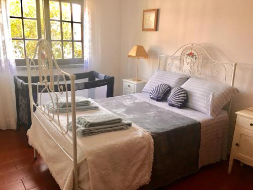 a bedroom with a white bed with blue pillows at Silver Coast Beach House in Torres Vedras