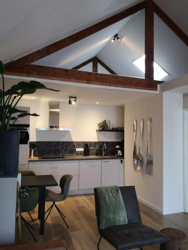 a kitchen with a table and chairs in a room at Stads-Loft Goes in Goes