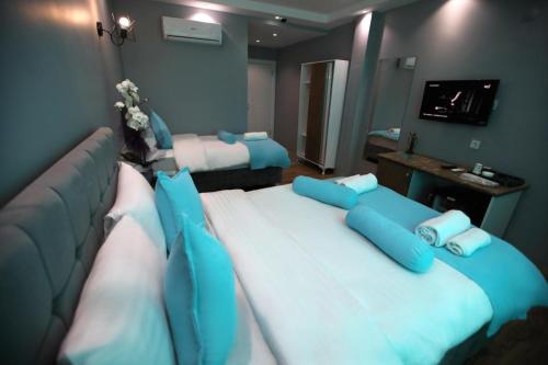a room with two large beds with blue pillows at Grand Atakum Boutıque Hotel in Mahmutlu