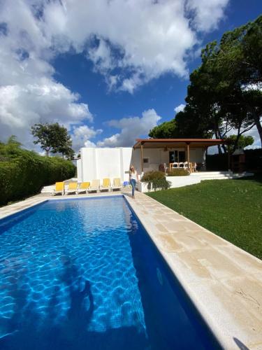 a swimming pool with blue water in front of a house at Villa Zen in Albufeira
