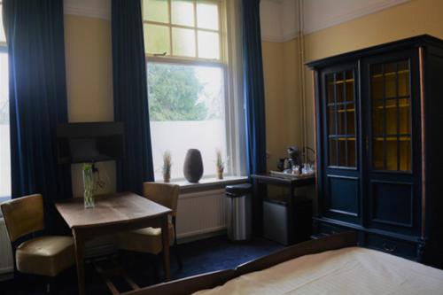 1 dormitorio con cama, mesa y ventana en DeVilla, en Rijs