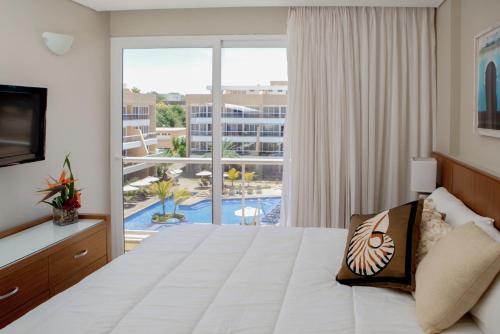 a hotel room with a bed and a large window at Hotel Margarita Real in Pampatar