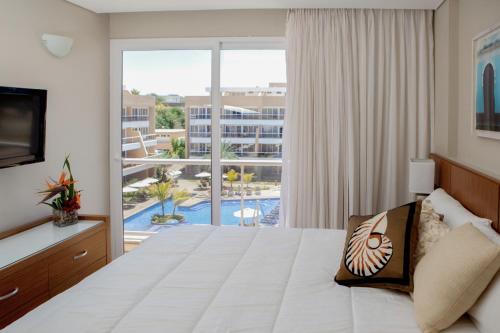 a hotel room with a bed and a large window at Hotel Margarita Real in Pampatar