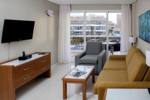 a living room with a couch and a tv at Hotel Margarita Real in Pampatar