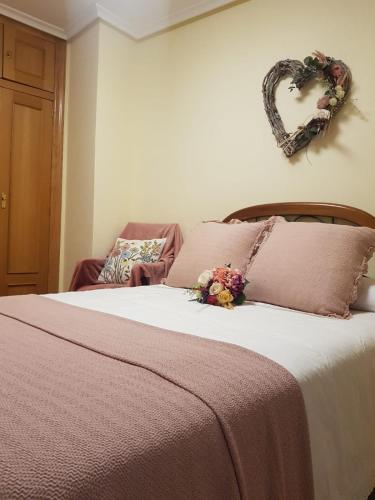 a bedroom with a bed with a heart sign on the wall at La Casa del Valle in Soncillo