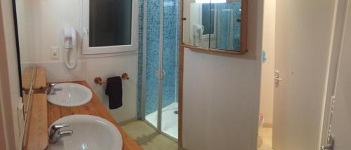 a bathroom with a sink and a shower with a mirror at Villa Orion in Capbreton