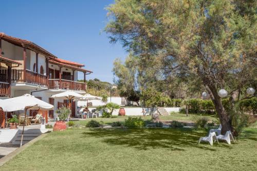 a resort with a yard with chairs and a tree at Villa Papapostolou in Ierissos