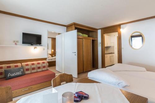 a room with two beds and a table and a tv at Appartement Haus Zalim in Brand