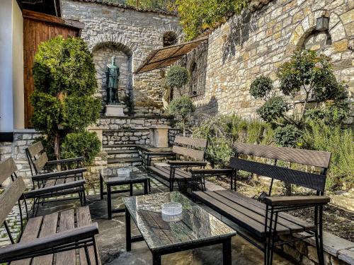 a group of benches sitting next to a stone wall at Hotel Mangalemi in Berat