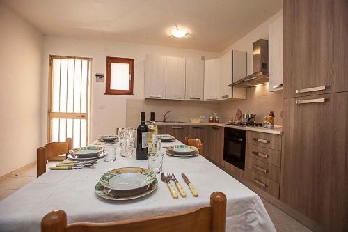 een keuken met een tafel met borden en wijnflessen bij Apartments in Rosolina Mare 25088 in Rosolina Mare